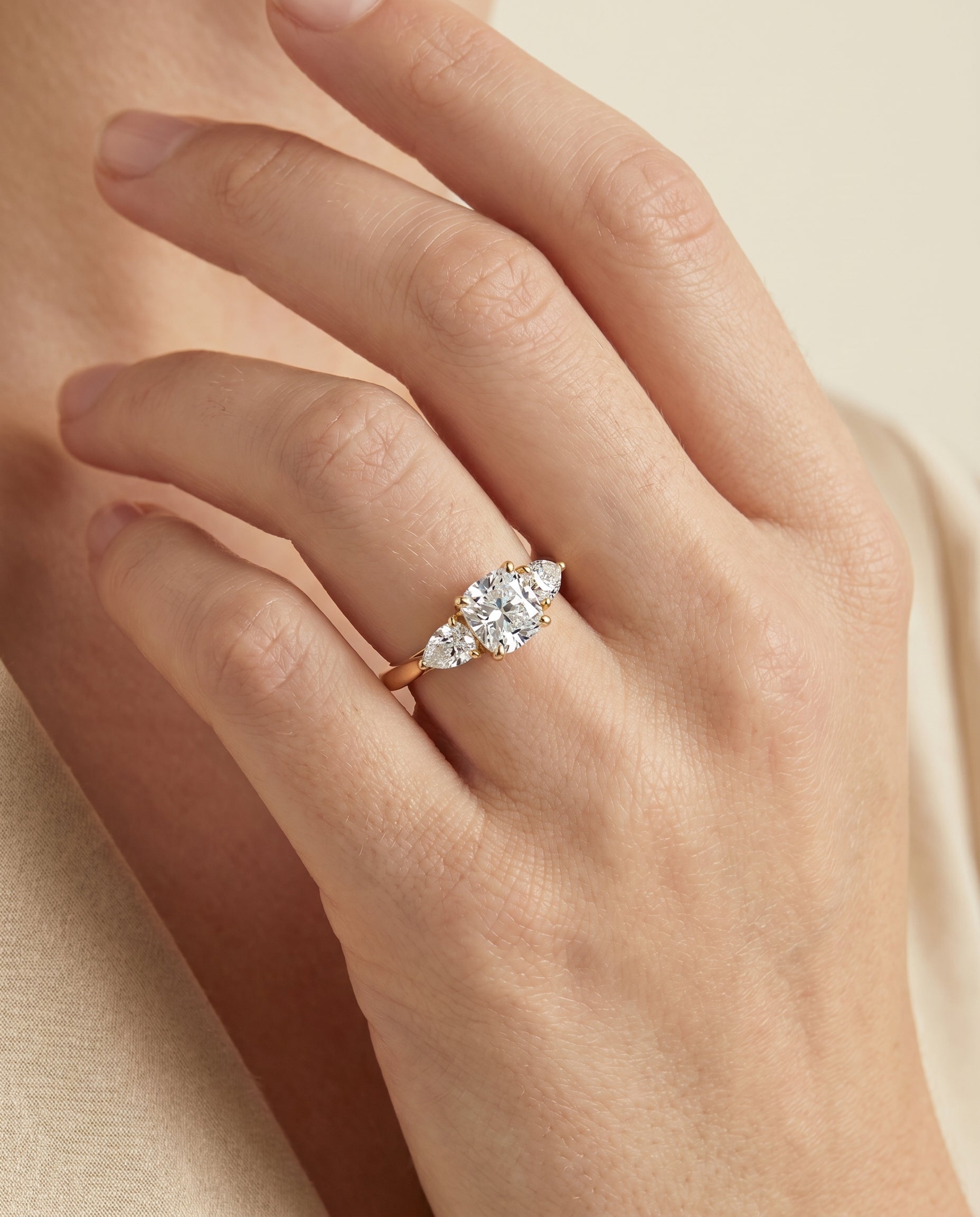 Angelica Select Three Stone Matched Cushion Cut Lab Diamond Engagement Ring in 18K Yellow Gold, shown on hand | RockHer
