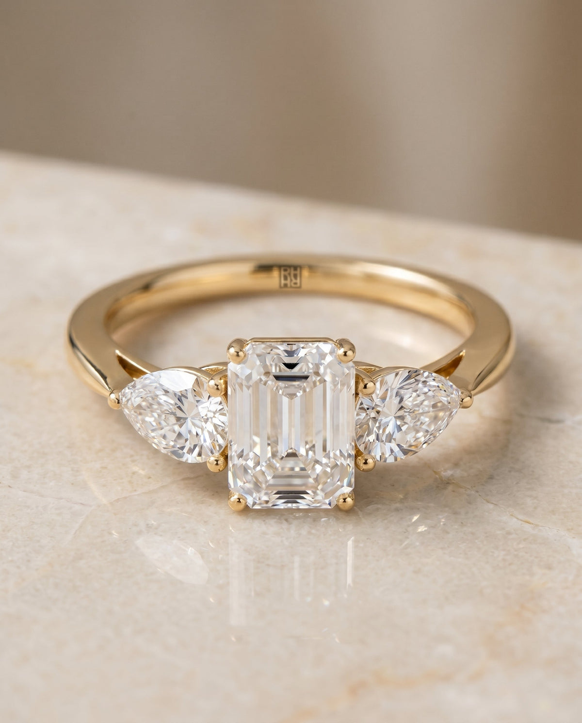 Angelica Select Three Stone Emerald Cut Lab Diamond Engagement Ring in 18K Yellow Gold, shown on hand, angled | RockHer