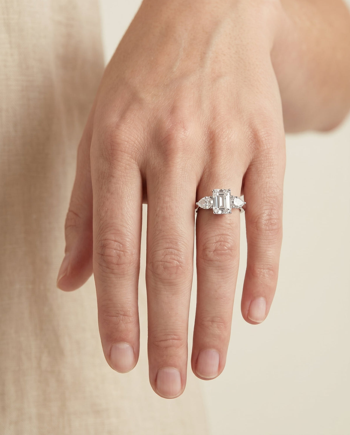 Angelica Select Three Stone Emerald Cut Lab Diamond Engagement Ring in Platinum, shown on hand | RockHer