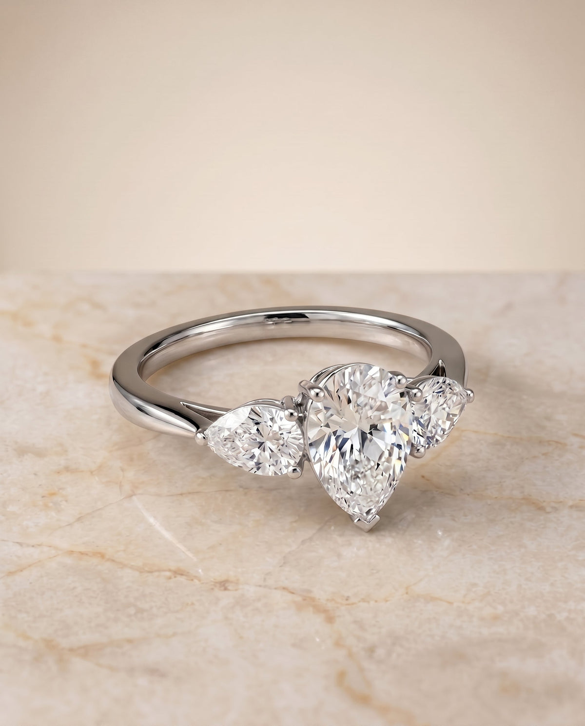 Angelica Select Three Stone Pear Lab Diamond Engagement Ring in 18K White Gold, shown on hand, angled | RockHer