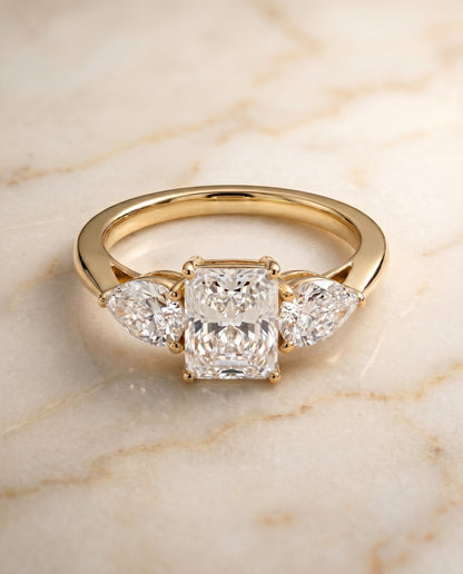 Angelica Select Three Stone Radiant Cut Lab Diamond Engagement Ring in 18K Yellow Gold, shown on hand, angled | RockHer
