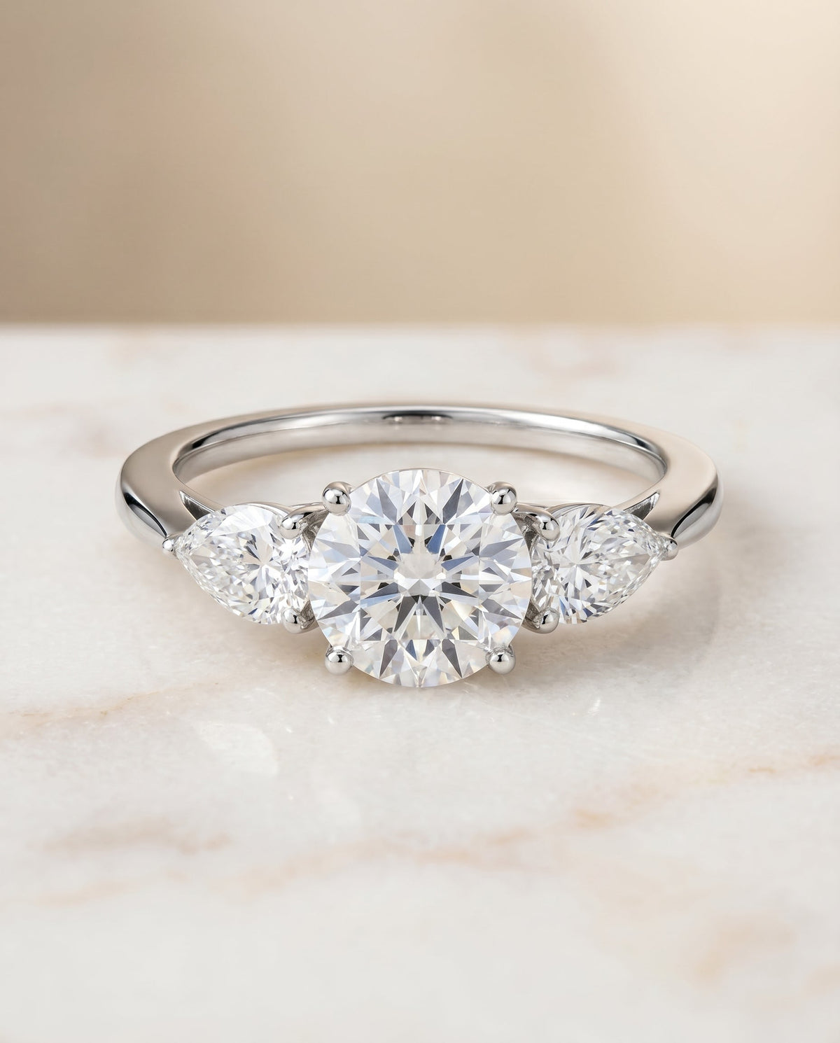 Angelica Select Three Stone Round Lab Diamond Engagement Ring in Platinum, shown on hand, angled | RockHer
