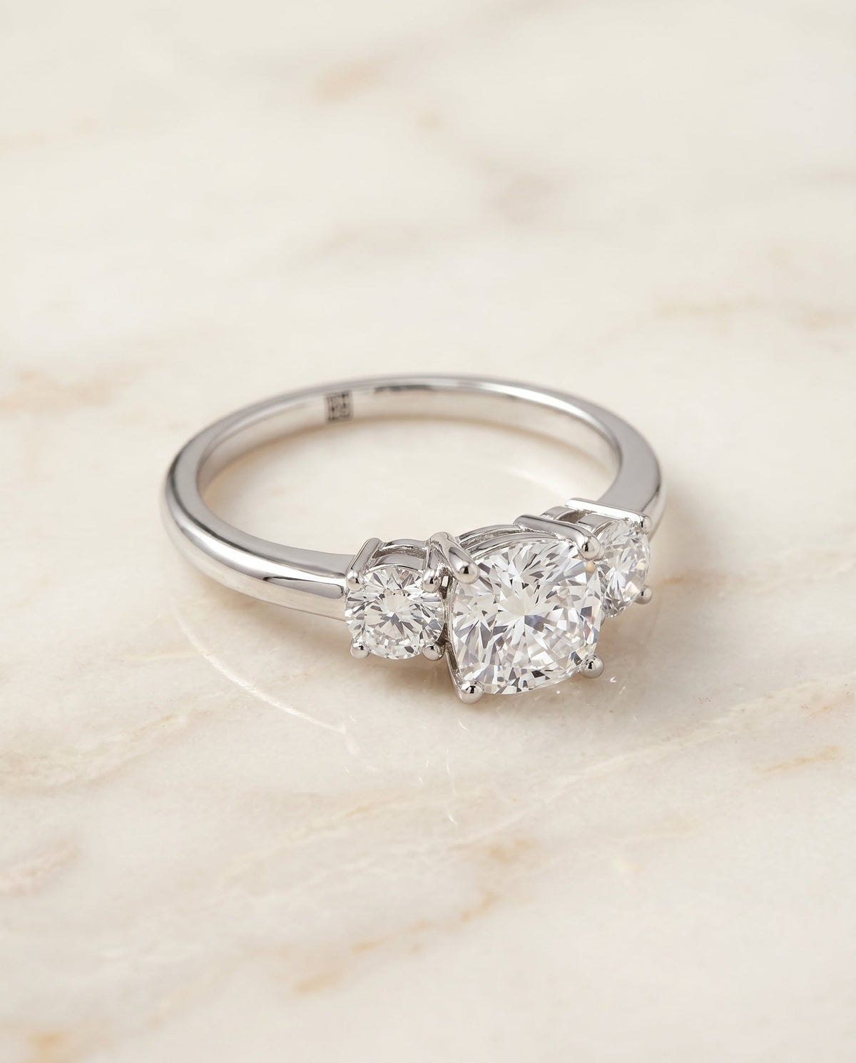 Anita Select Classic Three Stone Cushion Cut Lab Diamond Engagement Ring in Platinum, shown on hand, angled | RockHer
