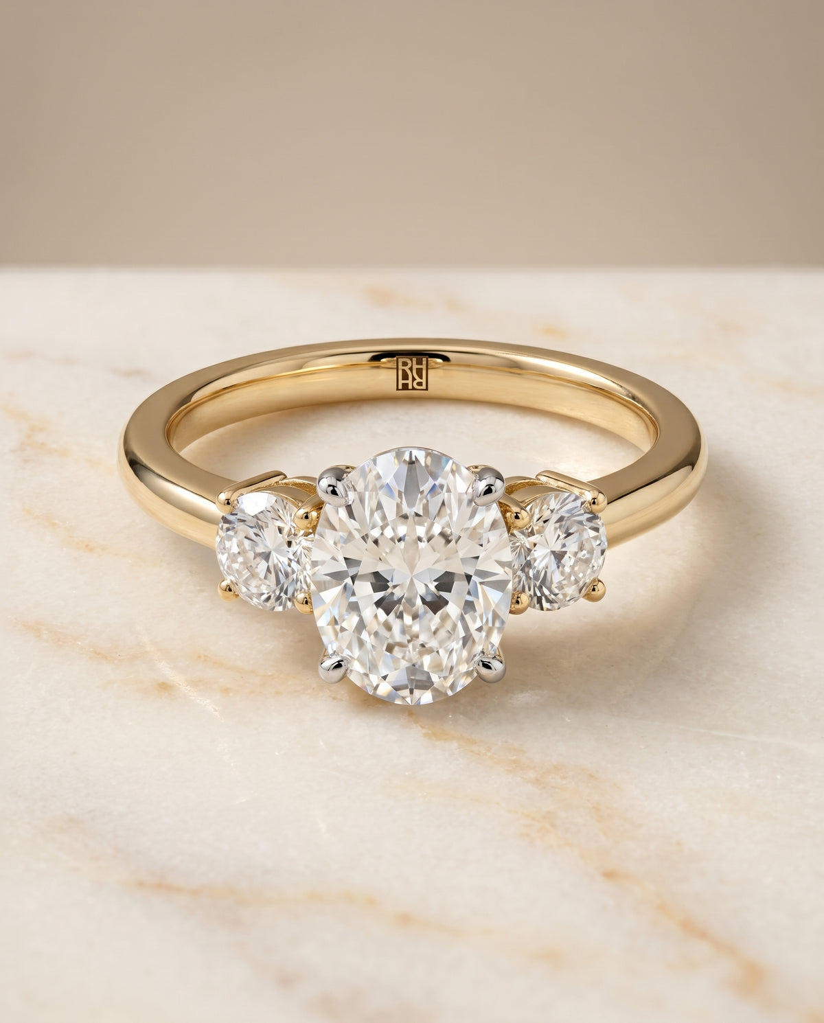 Oval three stone engagement ring in 18K yellow gold