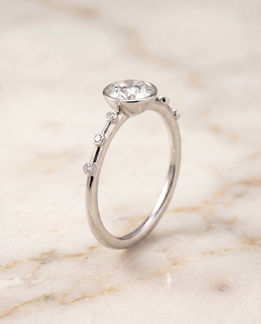 Brandi Select Bezel Accent Solitaire Emerald Cut in 18K White Gold – view 1