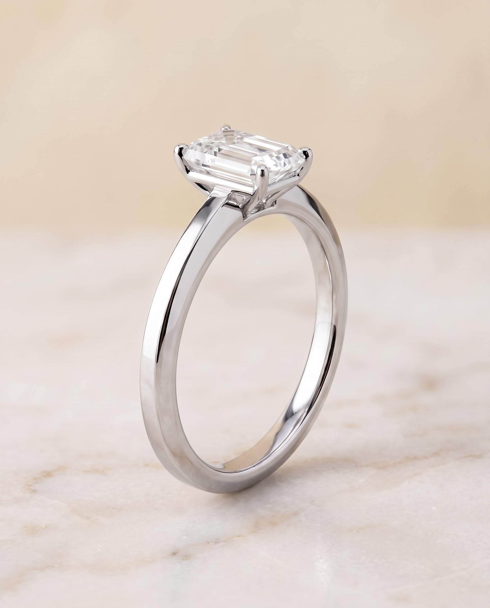 The Carmen Beveled Edge Comfort Fit Solitaire Emerald Cut Engagement Ring Setting in 18K White Gold