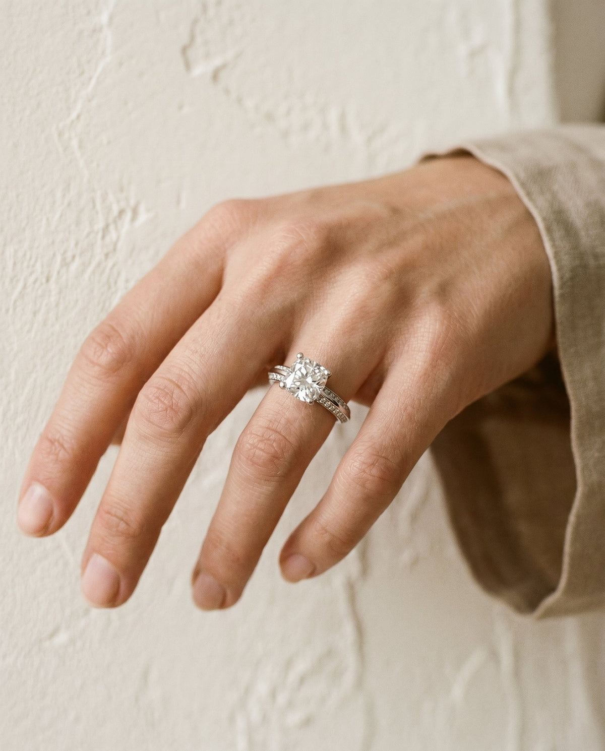 Clover Select Knife Edge Pavé Cushion Cut Lab Diamond Engagement Ring in Platinum, shown on hand, angled | RockHer