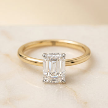 The Cyndi Curved Hidden Halo Solitaire Emerald Cut Engagement Ring Setting in 18K Yellow Gold