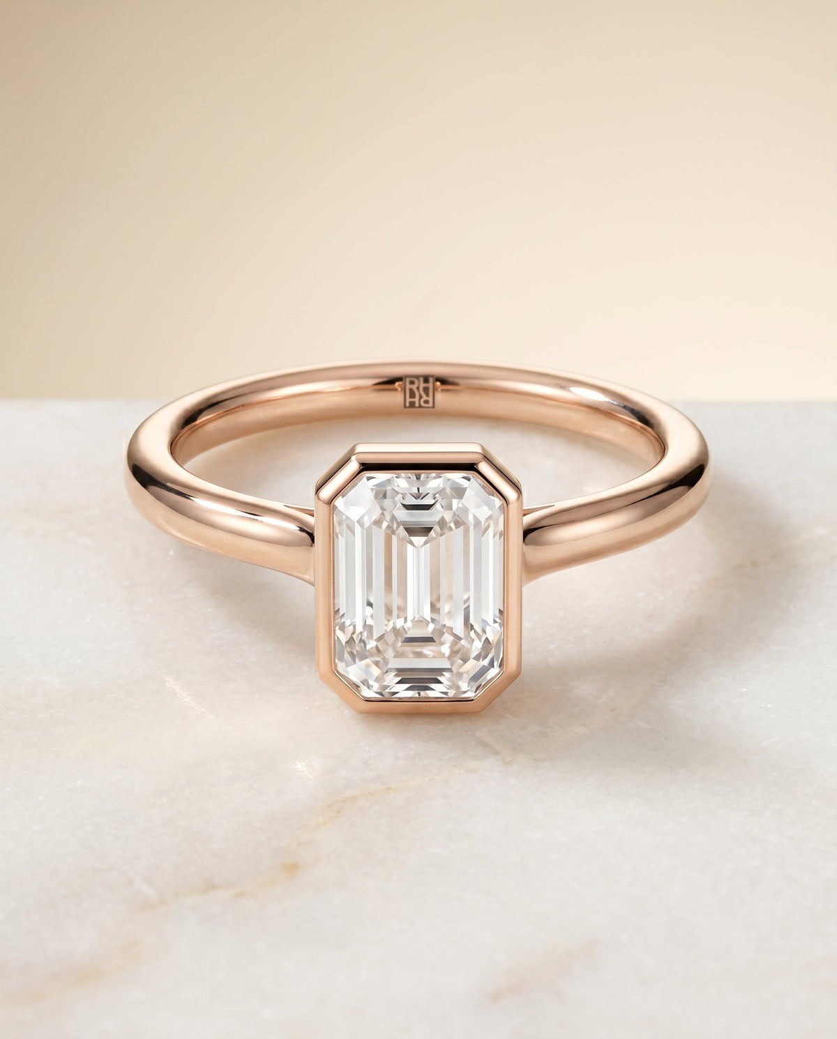 Duran Select Simple Bezel Solitaire Emerald Cut Lab Diamond Engagement Ring in 14K Rose Gold, shown on hand, angled | RockHer