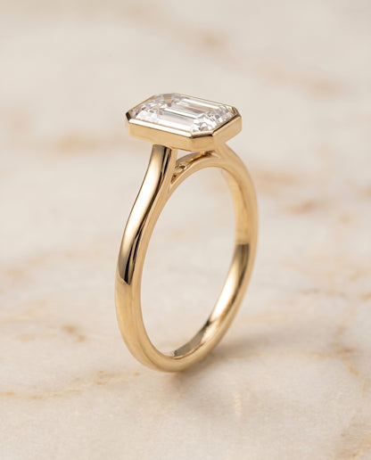 The Duran Simple Bezel Solitaire Emerald Cut Engagement Ring Setting in 18K Yellow Gold