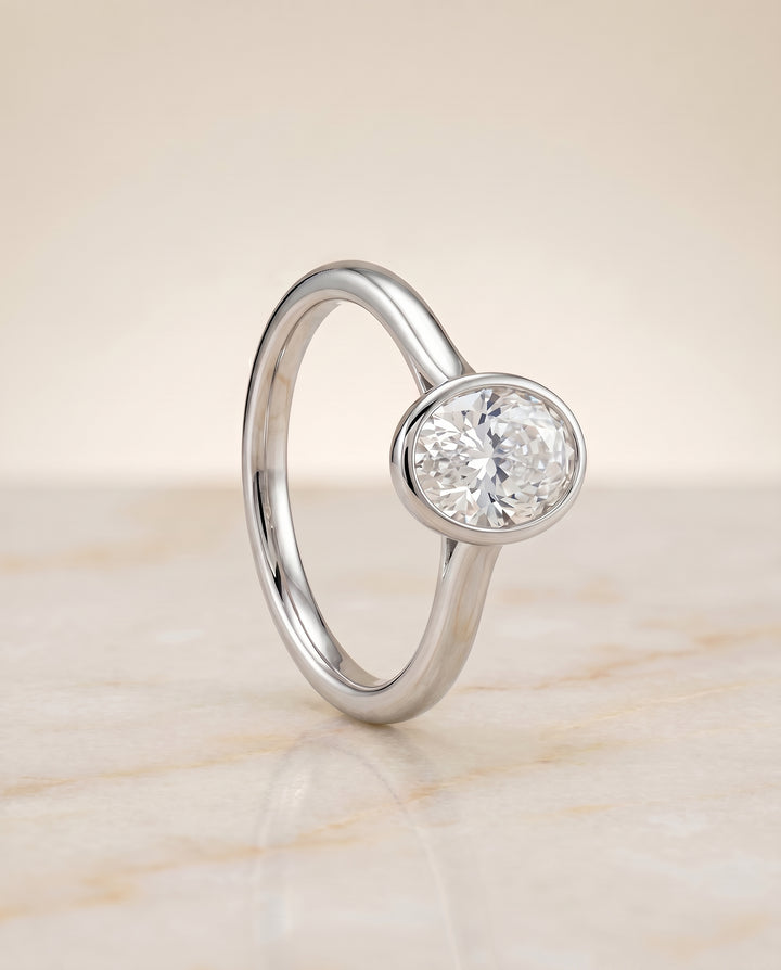 The Duran Simple Bezel Solitaire Engagement Ring Setting for Oval Diamonds in 18K White Gold