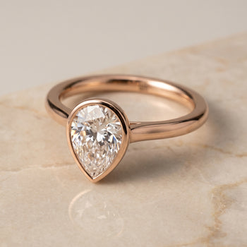 The Duran Simple Bezel Solitaire Pear Engagement Ring Setting in 14K Rose Gold