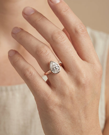 Duran Select Simple Bezel Solitaire Pear Lab Diamond Engagement Ring in 14K Rose Gold, shown on hand | RockHer