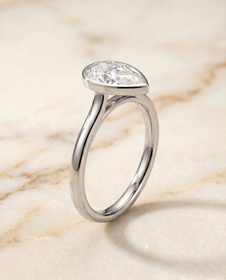 The Duran Bezel Solitaire Engagement Ring Setting for Pear Diamonds in 18K White Gold
