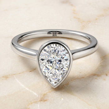 The Duran Simple Bezel Solitaire Pear Engagement Ring Setting in Platinum