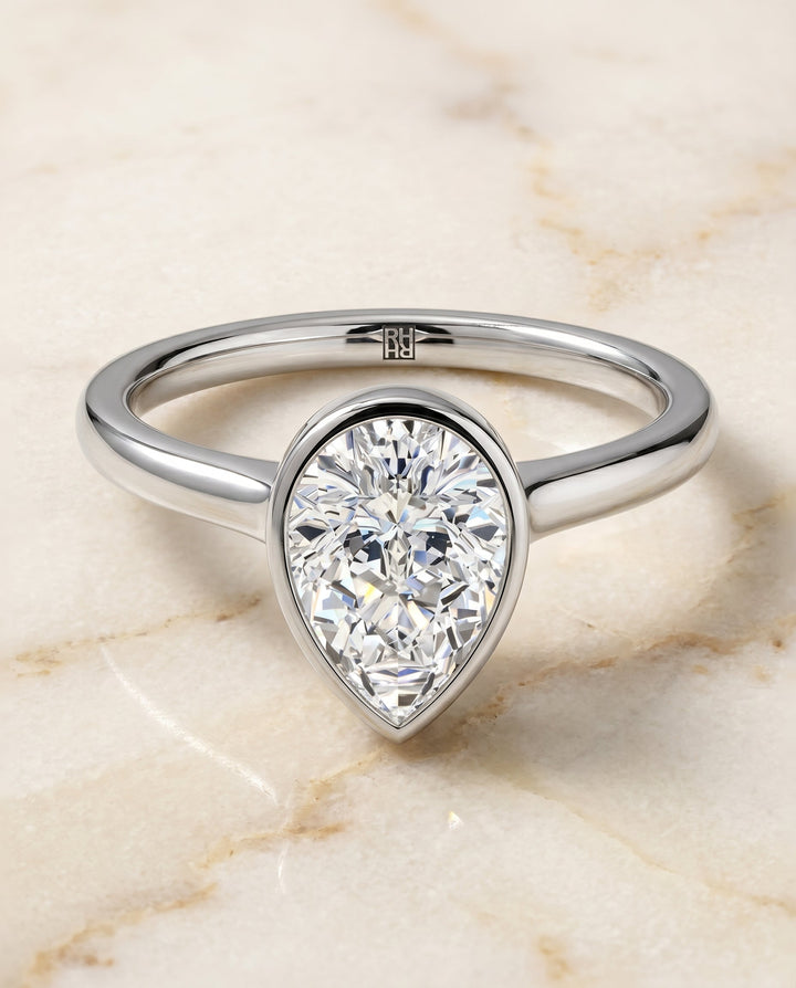 Duran Select Simple Bezel Solitaire Pear Lab Diamond Engagement Ring in 18K White Gold, shown on hand, angled | RockHer
