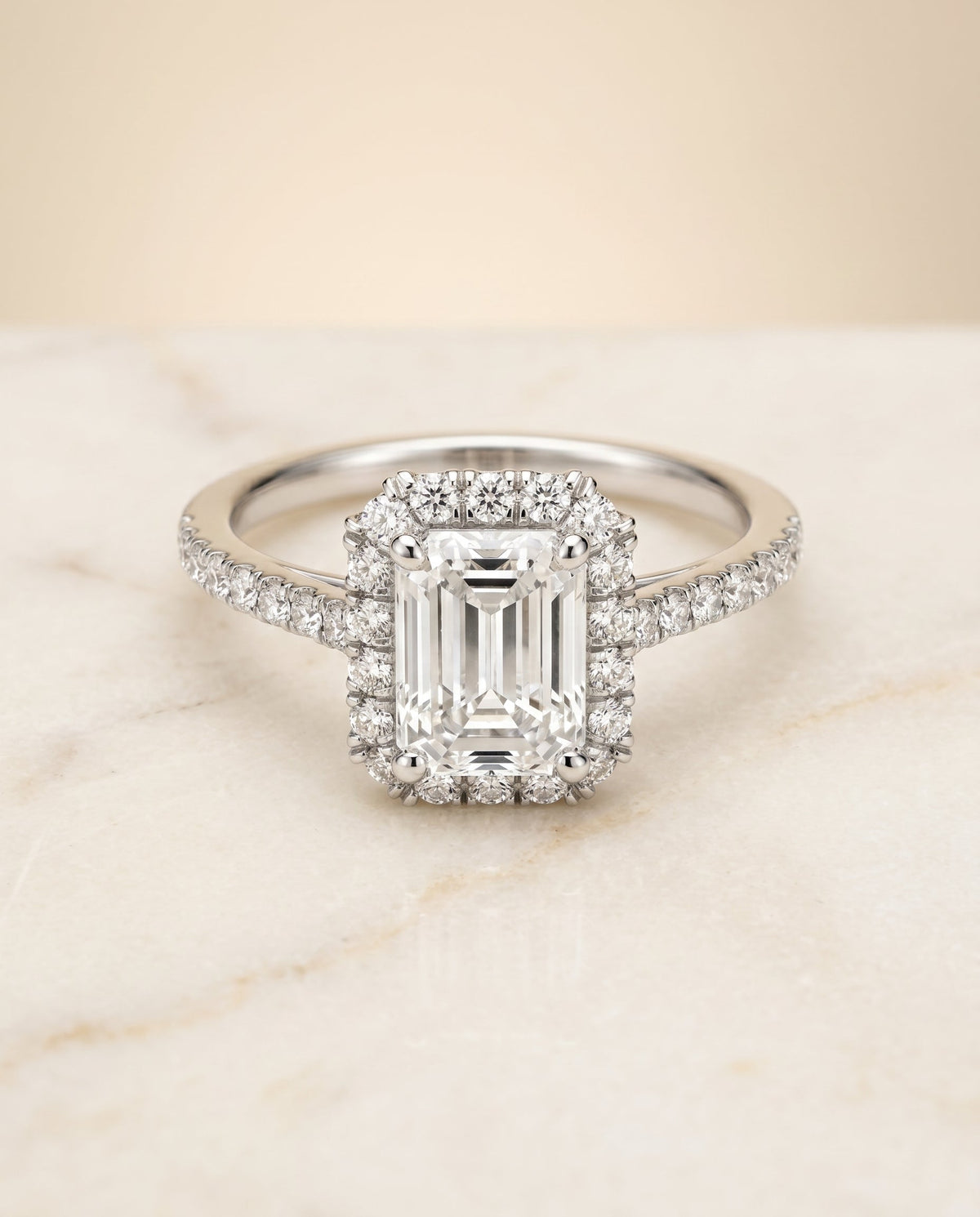 Dylan Select Petite French Pavé Halo Emerald Cut Lab Diamond Engagement Ring in Platinum, shown on hand, angled | RockHer