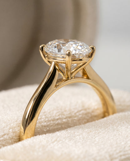 The Elena Timeless Graduated Beveled Shank Solitaire Oval Engagement Ring Setting in 18K Yellow Gold