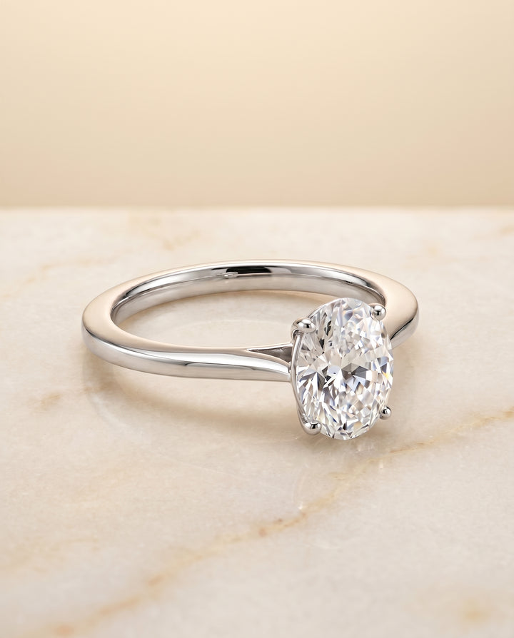 The Elena Timeless Graduated Beveled Shank Solitaire Oval Engagement Ring Setting in Platinum