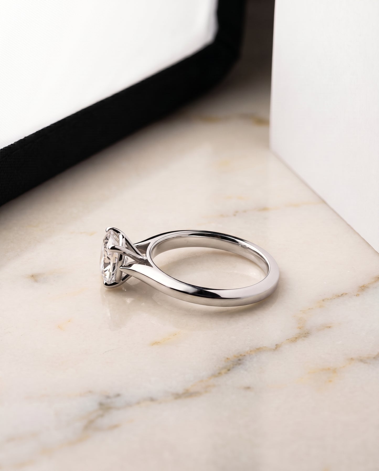 The Elena Timeless Graduated Beveled Shank Solitaire Cushion Cut Engagement Ring Setting in Platinum
