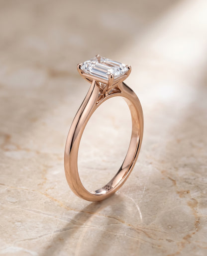The Elena Timeless Graduated Beveled Shank Solitaire Emerald Cut Engagement Ring Setting in 14K Rose Gold