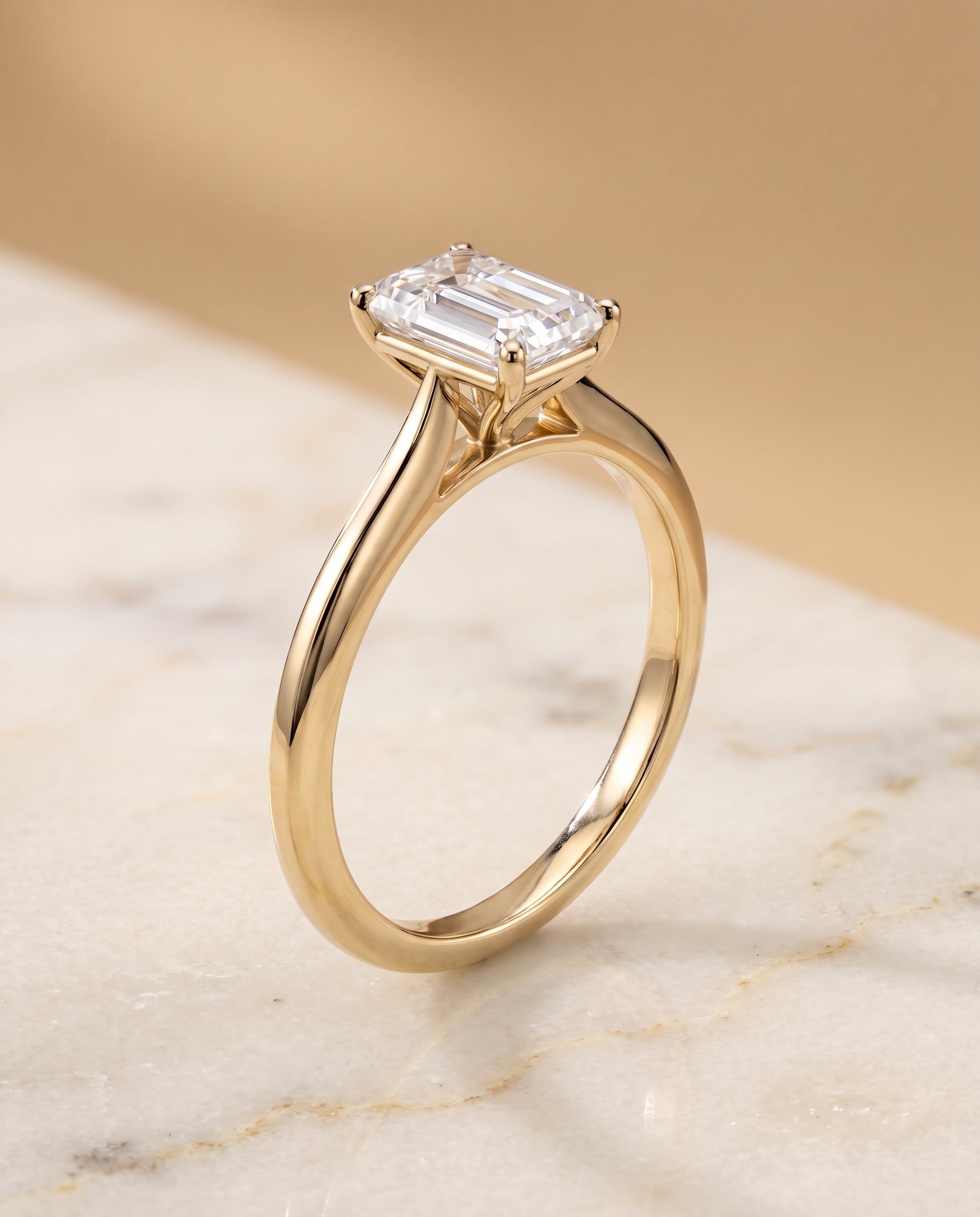 The Elena Timeless Graduated Beveled Shank Solitaire Emerald Cut Engagement Ring Setting in 18K Yellow Gold