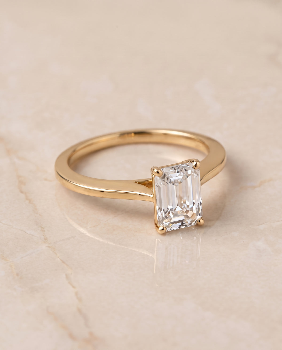 The Elena Timeless Graduated Beveled Shank Solitaire Emerald Cut Engagement Ring Setting in 18K Yellow Gold