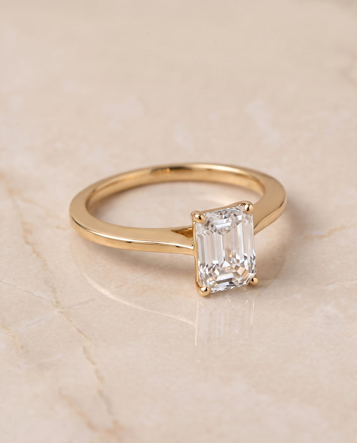 The Elena Timeless Graduated Beveled Shank Solitaire Emerald Cut Engagement Ring Setting in 18K Yellow Gold