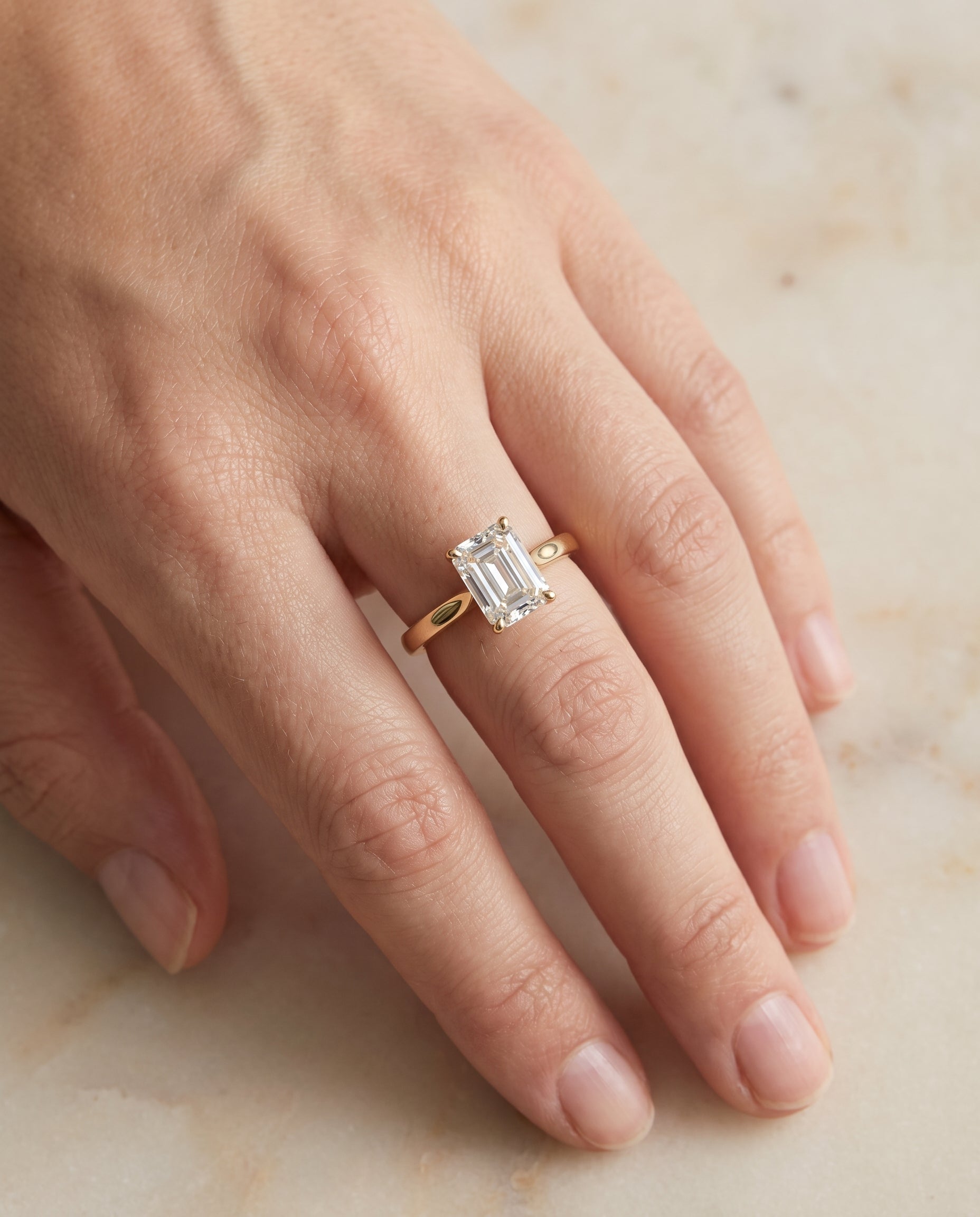The Elena Timeless Graduated Beveled Shank Solitaire Emerald Cut Engagement Ring Setting in 18K Yellow Gold