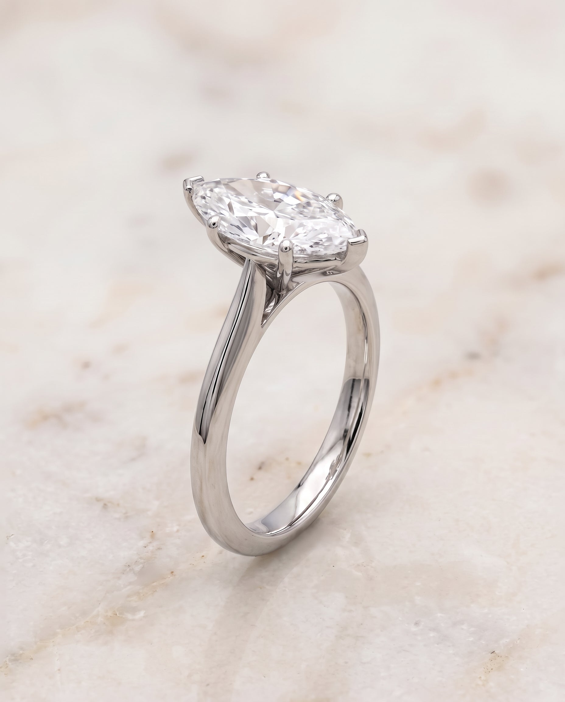 The Elena Timeless Graduated Beveled Shank Solitaire Marquise Engagement Ring Setting in 18K White Gold