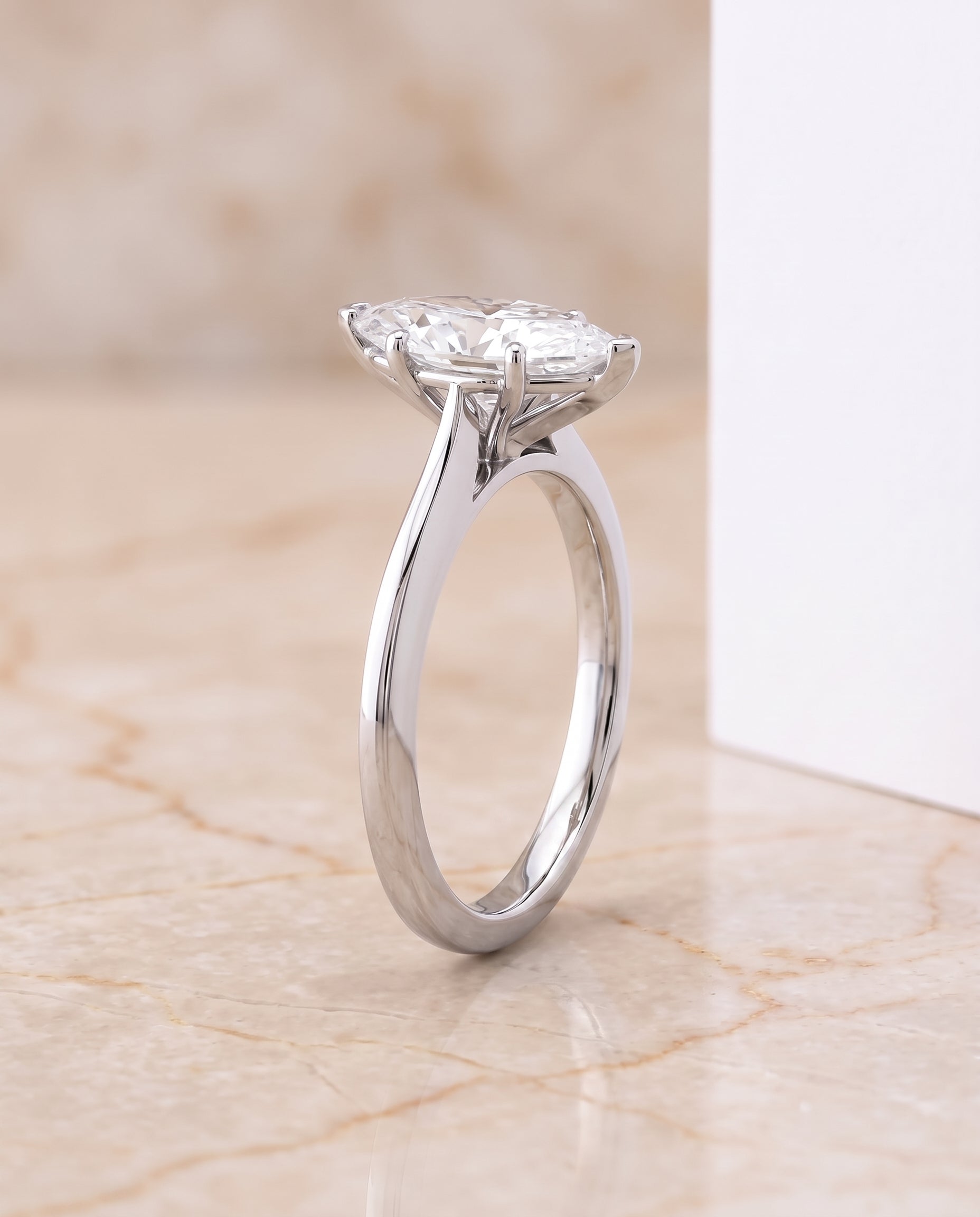 The Elena Timeless Graduated Beveled Shank Solitaire Marquise Engagement Ring Setting in 18K White Gold