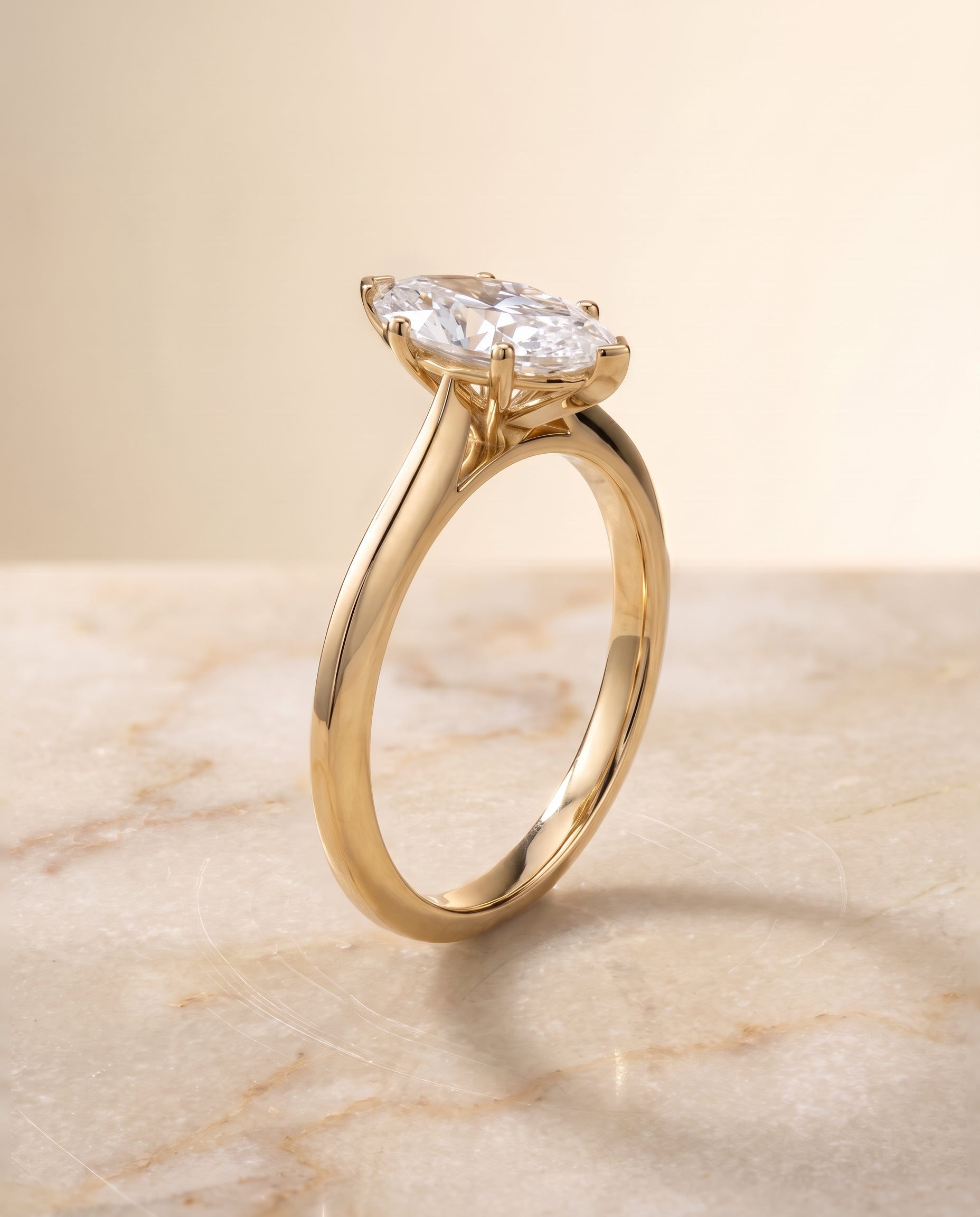 The Elena Timeless Graduated Beveled Shank Solitaire Marquise Engagement Ring Setting in 18K Yellow Gold