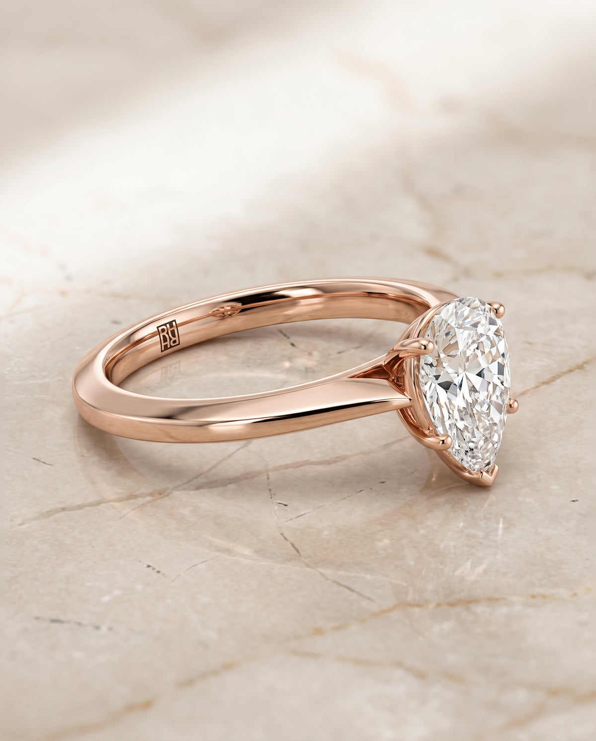 The Elena Timeless Graduated Beveled Shank Solitaire Pear Engagement Ring Setting in 14K Rose Gold