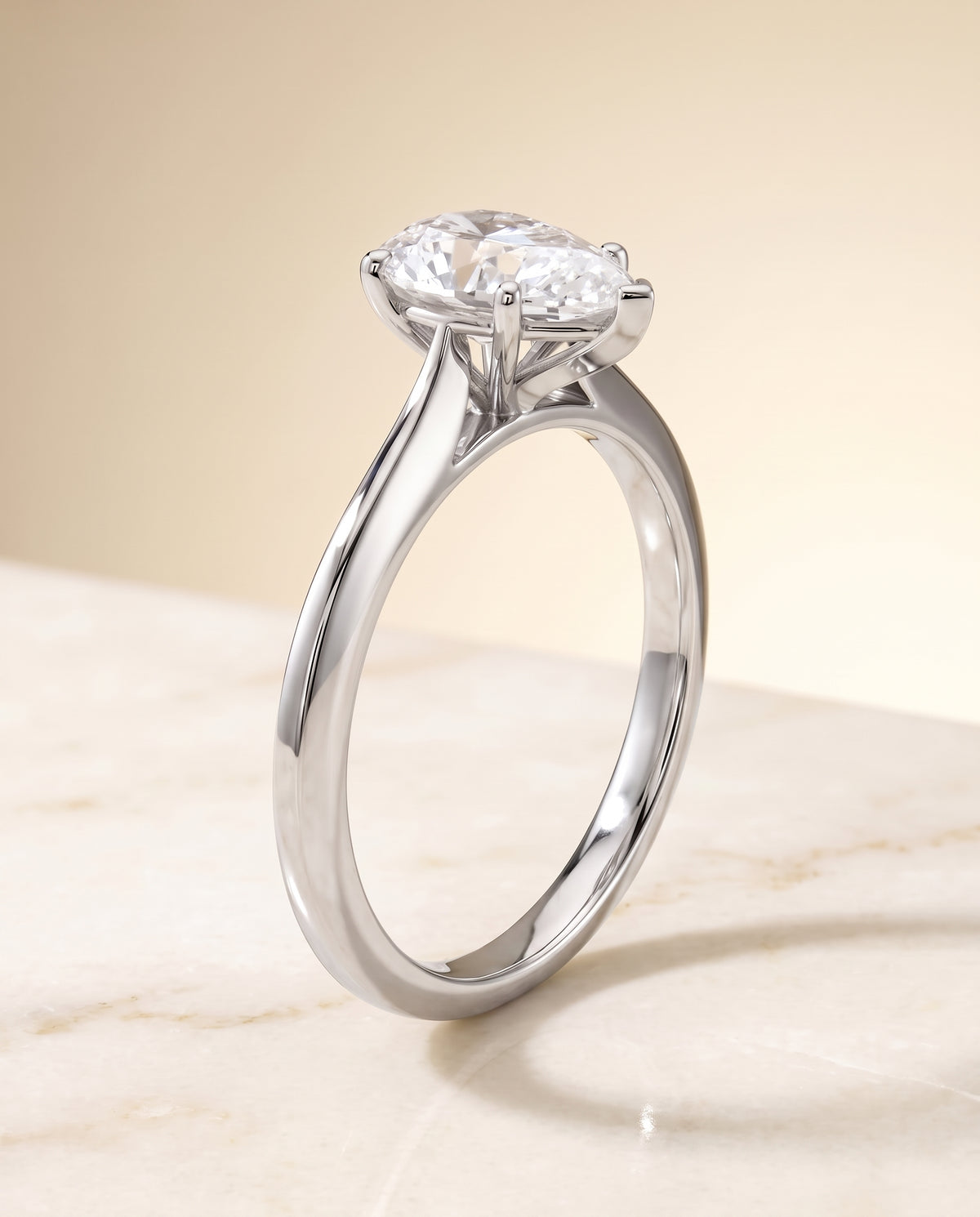 The Elena Timeless Graduated Beveled Shank Solitaire Pear Engagement Ring Setting in Platinum