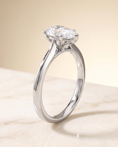 The Elena Timeless Graduated Beveled Shank Solitaire Pear Engagement Ring Setting in Platinum