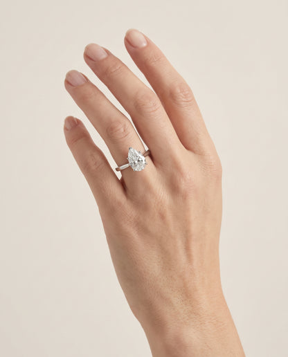 The Elena Timeless Graduated Beveled Shank Solitaire Pear Engagement Ring Setting in Platinum