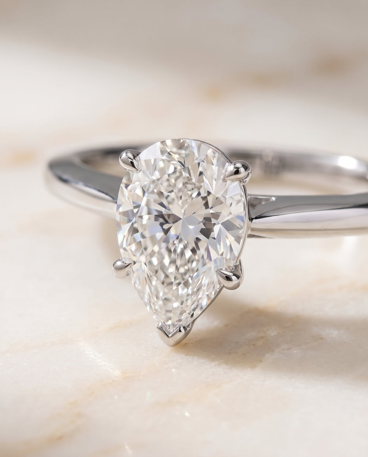 The Elena Timeless Graduated Beveled Shank Solitaire Pear Engagement Ring Setting in Platinum