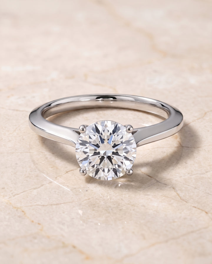 The Elena Timeless Graduated Beveled Shank Solitaire Round Engagement Ring Setting in 18K White Gold
