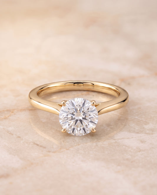 The Elena Timeless Graduated Beveled Shank Solitaire Round Engagement Ring Setting in 18K Yellow Gold