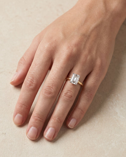 The Floria Comfort Fit Claw Prong Solitaire Emerald Cut Engagement Ring Setting in 18K Yellow Gold