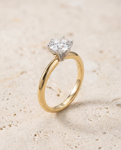The Giovanna Pinched Comfort Fit Claw Prong Solitaire Round Engagement Ring Setting in 18K Yellow Gold
