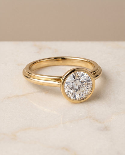 Hayley Select Bezel Solitaire Round Lab Diamond Engagement Ring in 18K Yellow Gold, shown on hand, angled | RockHer