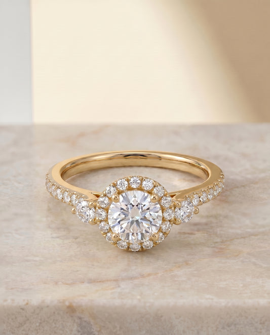 The Ivy Three Stone with Halo Engagement Ring Setting for Round Diamonds in 18K Yellow Gold