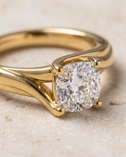 The Joplin Twisted Bypass Solitaire Cushion Cut Engagement Ring Setting in 18K Yellow Gold