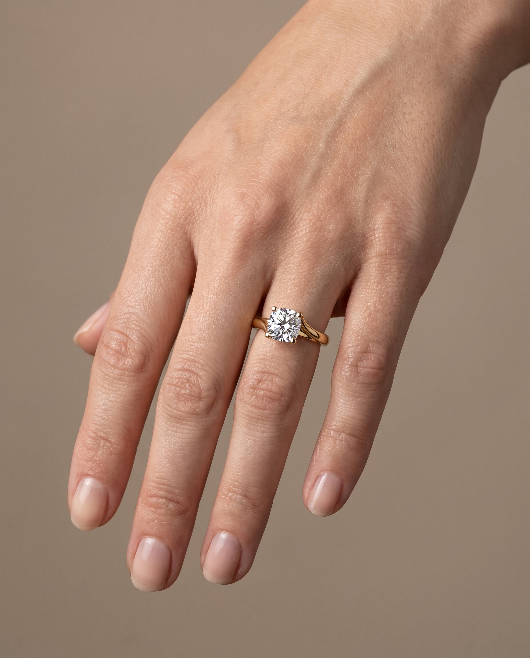 The Joplin Twisted Bypass Solitaire Cushion Cut Engagement Ring Setting in 18K Yellow Gold