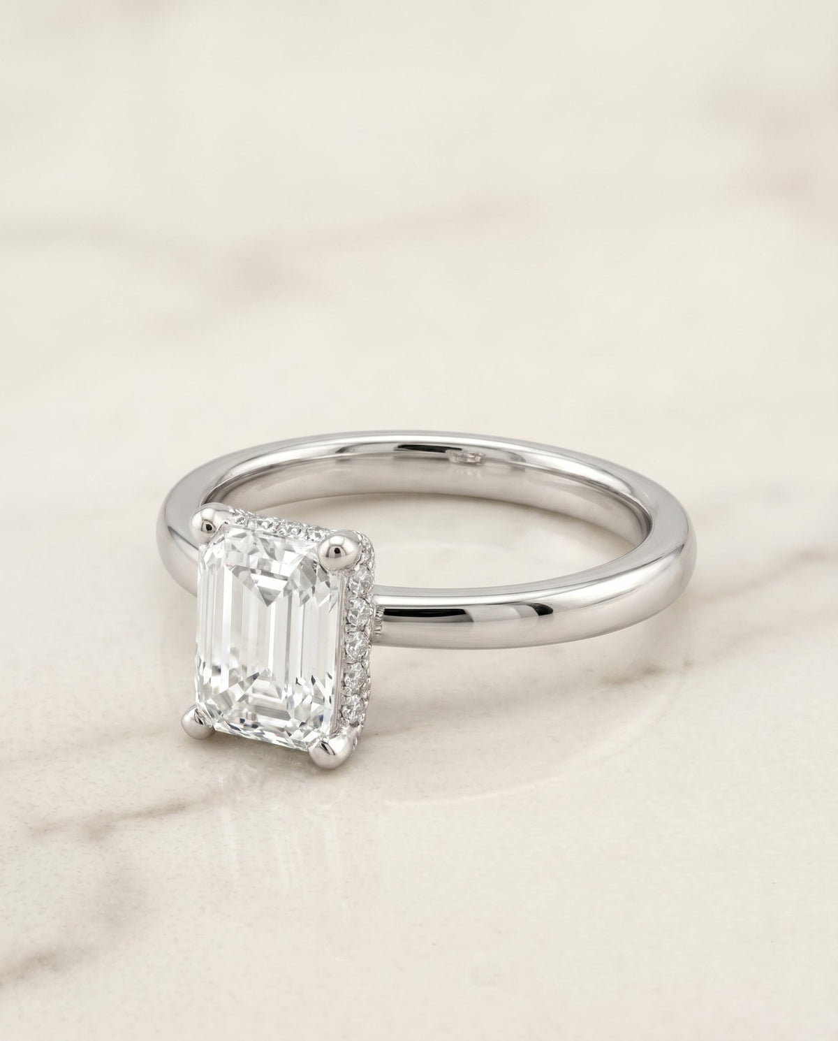 Lana Select Hidden Halo Emerald Cut Lab Diamond Engagement Ring in 18K White Gold, shown on hand, angled | RockHer