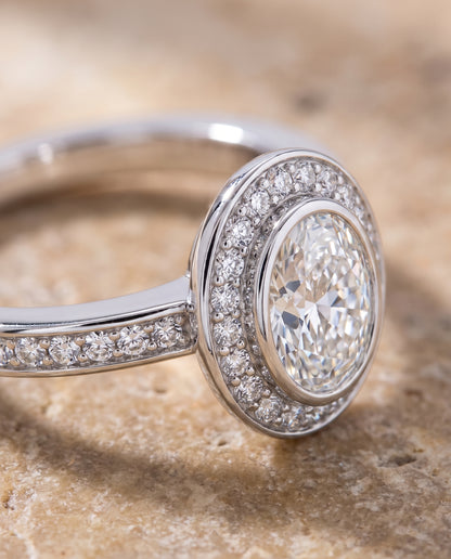 The Marcia Bezel Halo Channel Band Oval Engagement Ring Setting in 18K White Gold
