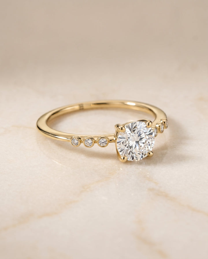 Peggy Select Bezel Accent Solitaire Round Lab Diamond Engagement Ring in 18K Yellow Gold, shown on hand, angled | RockHer