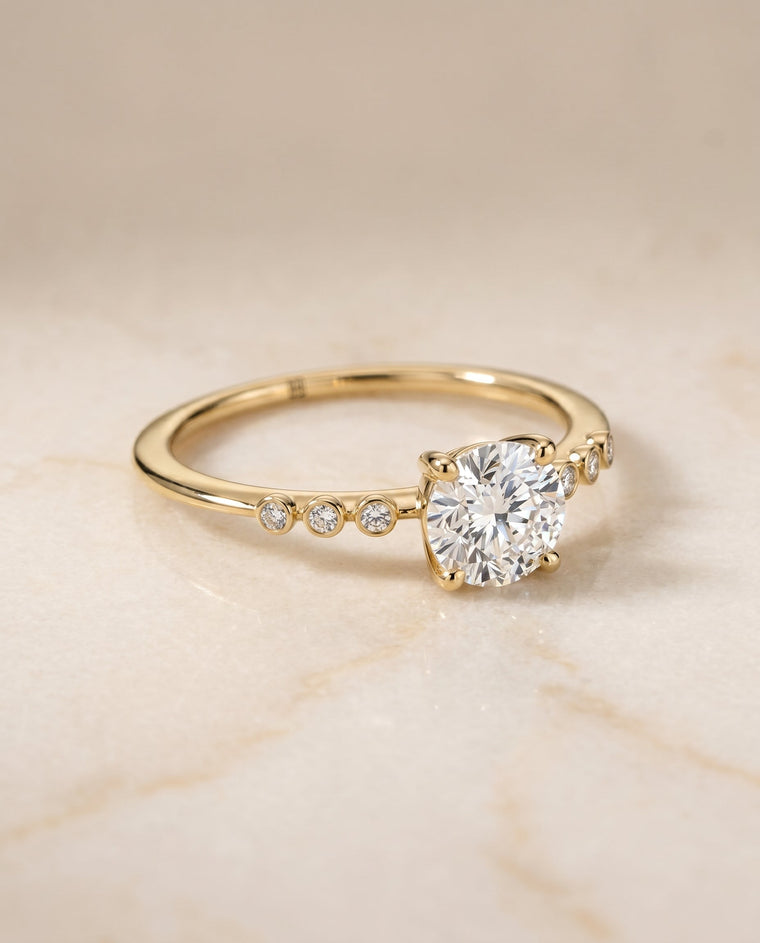 The Peggy Select Bezel Accent Solitaire Round Lab Diamond Engagement Ring in 18K Yellow Gold