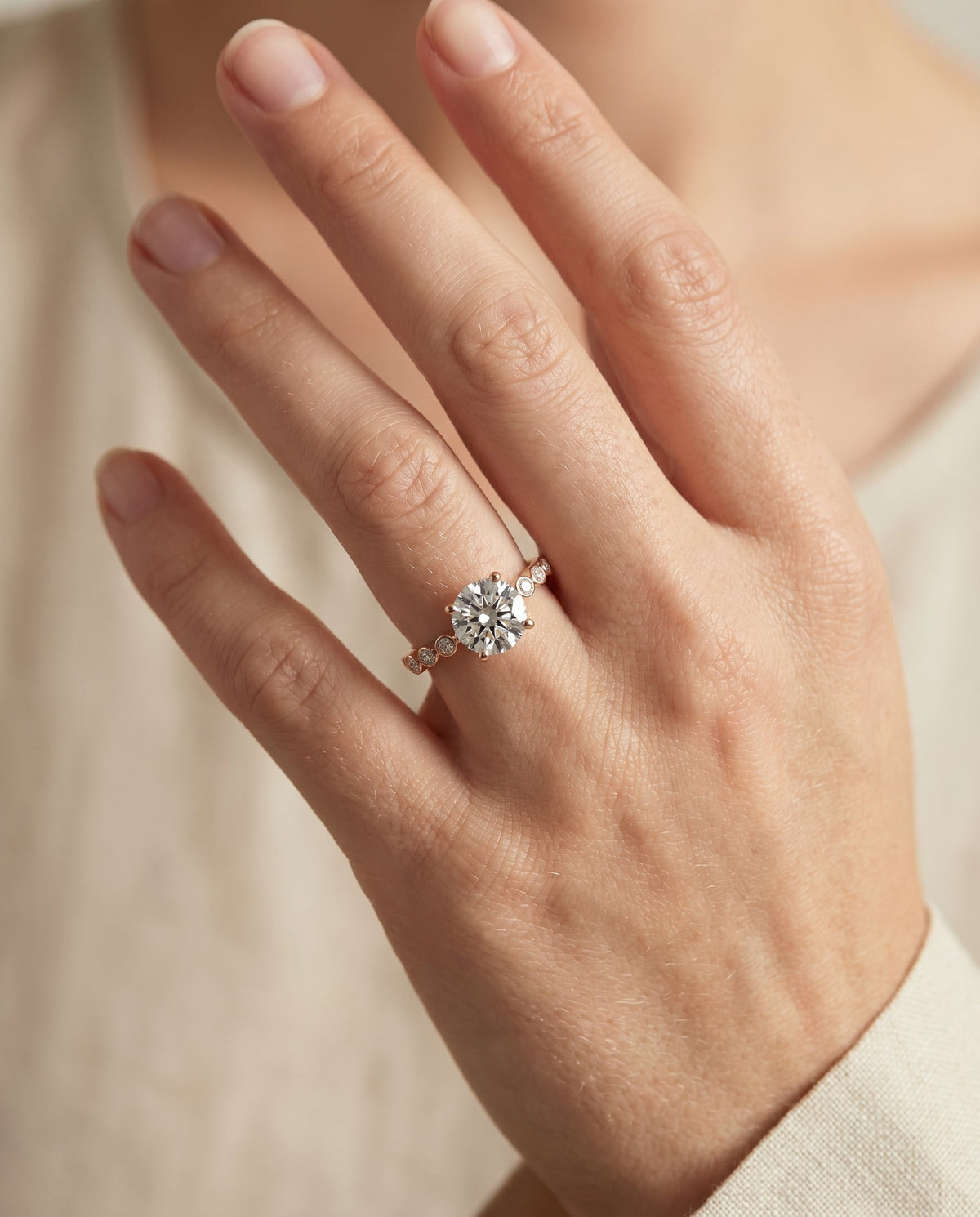 Peggy Select Bezel Accent Solitaire Round Lab Diamond Engagement Ring in 14K Rose Gold, shown on hand | RockHer